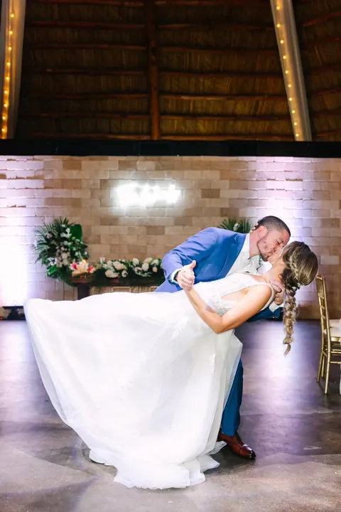 Newlyweds share a dip kiss on the indoor dance floor.