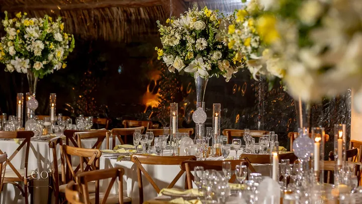 Tall floral centerpieces and candles dress elegant reception tables.