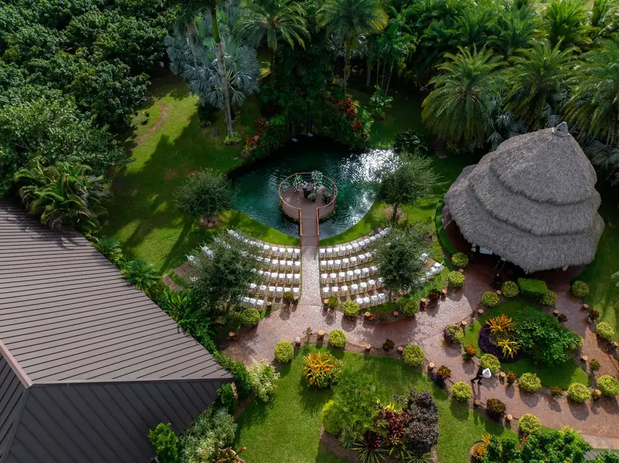 Aerial view of the tropical gardens, pond, waterfall ceremony area, and covered pavilion at Longan’s Place
