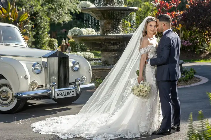 Bride and groom beside a vintage wedding car