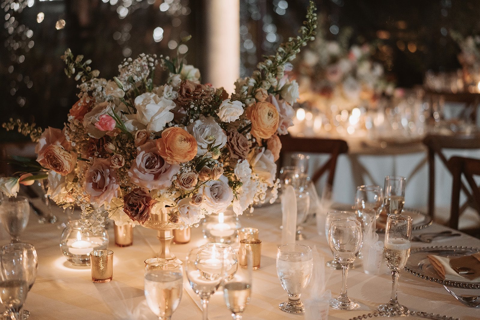 Soft floral centerpiece and candlelit place settings at Longan’s Place