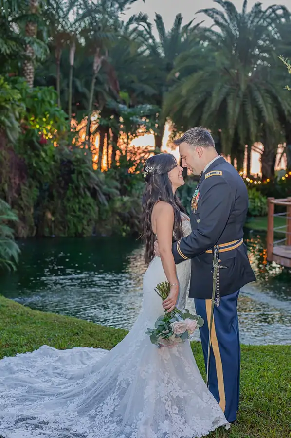 Newlyweds beside the pond and rock waterfall at Longan’s Place at sunset